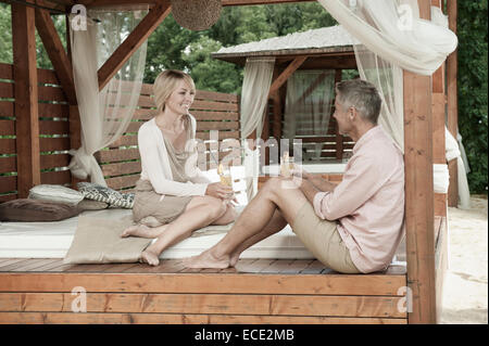 Couple assis cocktail chic jardin heureux Banque D'Images