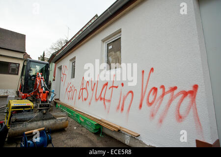 Vorra, Allemagne. Dec 12, 2014. L'écrit à côté de la croix gammée sur le mur d'une maison indique 'Kein Asylat (Asylant) dans ssylum Vorra' (Pas d'asile en Vorra) dans Vorra, Allemagne, 12 décembre 2014. Trois bâtiments dans le centre du village de Vorra, un ancien hôtel, un bâtiment résidentiel à proximité et une ancienne grange, étaient destinés à accueillir les réfugiés, incendié dans la nuit de jeudi 12 décembre. Enquête sur la police sur suspecion de l'incendie criminel. Photo : Daniel Karmann/dpa/Alamy Live News Banque D'Images