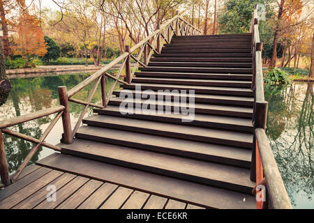 Pont en bois d'escaliers. Balade autour du lac de l'Ouest célèbre Park dans le centre-ville de Hangzhou, Chine. Vintage photo couleur avec filtre effi Banque D'Images