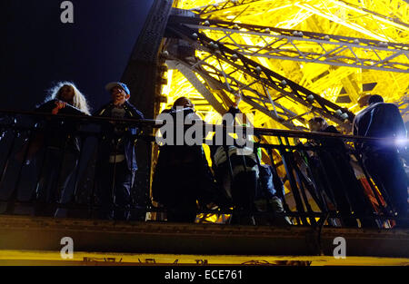 Regardant les touristes sur la Tour Eiffel par nuit Banque D'Images