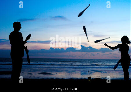 Des personnes non identifiées, jonglant sur la plage au coucher du soleil. Bali, Indonesi Banque D'Images