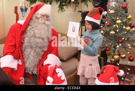 Séoul, Corée du Sud. Dec 12, 2014. Un enfant lit son souhait au Père Noël à Séoul, Corée du Sud, le 12 décembre 2014. Santa Claus de Rovaniemi de Finlande, la ville officielle du Père Noël, est arrivé à la Corée du Sud pour satisfaire aux souhaits de 20 enfants issus de familles pauvres. © Yao Sailawei Holiday/Xinhua/Alamy Live News Banque D'Images