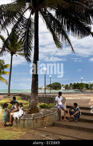 L'Ile Maurice, Mahebourg, front de mer, des familles assis dans l'ombre Banque D'Images