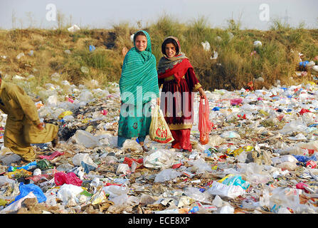 Islamabad, Pakistan. Dec 12, 2014. Les filles pakistanaises recherche pour recueillir les objets d'une décharge à Islamabad, Pakistan, le 12 décembre 2014. © Saadia Seher/Xinhua/Alamy Live News Banque D'Images