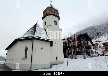 L'église du village et des chalets dans la région de Zoug, en Autriche. Zoug est dans la région de l'Arlberg. Banque D'Images