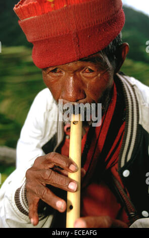 Tribu Ifugao homme jouant de la flûte. Rizières en terrasses. Point de vue. Banaue. Le nord de Luzon. Aux Philippines. Banaue (ou spe Banque D'Images