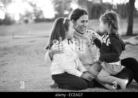 Mère assise dans le parc avec ses deux filles, Buenos Aires, Argentine Banque D'Images