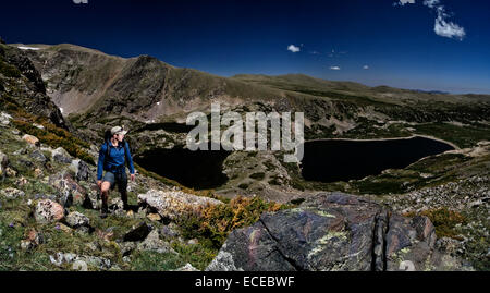 USA, Colorado, Montagnes Rocheuses, Homme debout au milieu des rochers sur montagne avec trois lacs vu ci-dessous Banque D'Images