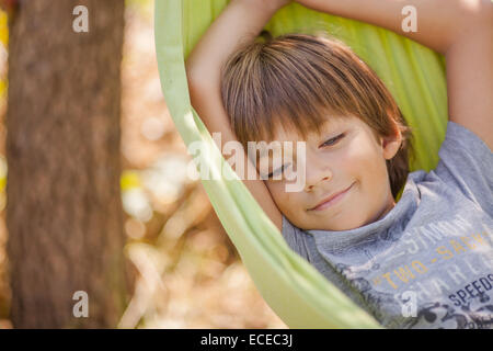 Portrait of smiling boy lying in hammock Banque D'Images