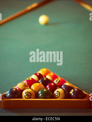 Close-up shot of pool balls en triangle en bois avec boule blanche en arrière-plan flou Banque D'Images