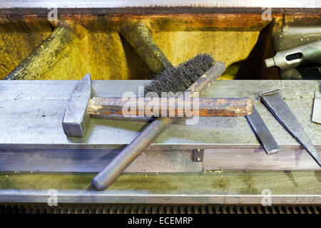 Marteau et brosse métal plate sur le châssis de la machine Banque D'Images