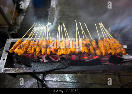 Bâtonnets de poulet satay épicé sur un gril barbecue charbon en Asie Banque D'Images