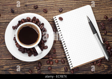 Tasse de café, un stylo et bloc-notes ouvert sur 24. Vue d'en haut Banque D'Images