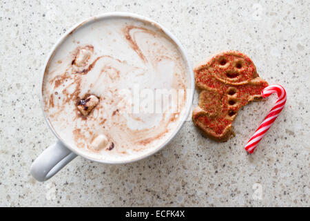 Chocolat chaud avec un gingerbread man avec un pied manquant à l'aide d'une canne à sucre Banque D'Images