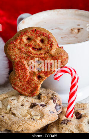 Chocolat chaud avec un gingerbread man avec un pied manquant à l'aide d'une canne à sucre Banque D'Images