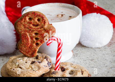 Chocolat chaud avec un gingerbread man avec un pied manquant à l'aide d'une canne à sucre Banque D'Images