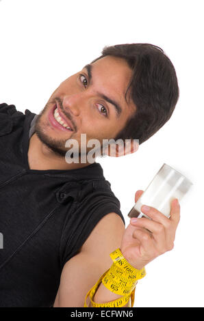 Beau jeune homme athlétique sourire enroulé autour d'un ruban à mesurer en verre de lait Banque D'Images