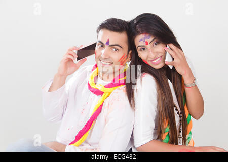 Couple marié indien Festival Holi téléphone parlant Banque D'Images