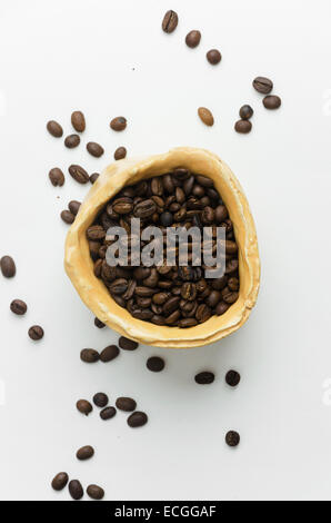 Grains de café dans un bol blanc rustique sur table, vue ci-dessus Banque D'Images