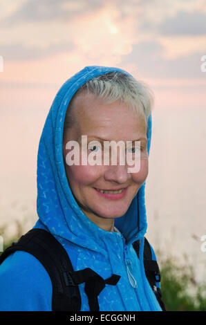 Portrait de la femme du nombre moyen d'années de voyage sur un fond de ciel du soir Banque D'Images