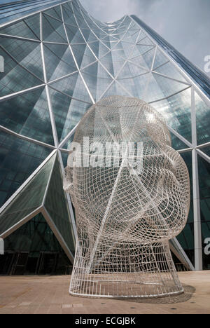 Un mètre douze sculptures de fil d'une jeune fille par la tête de l'artiste espagnol Jaume Plensa se tient juste en face de l'Arc de Calgary. Banque D'Images