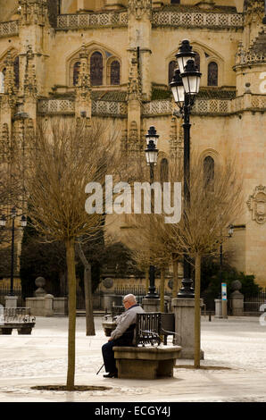 SEGOVIA, ESPAGNE - 3 mars 2013 : un vieil homme se reposant sur un banc de la place principale de Ségovie, en face de la cathédrale Banque D'Images