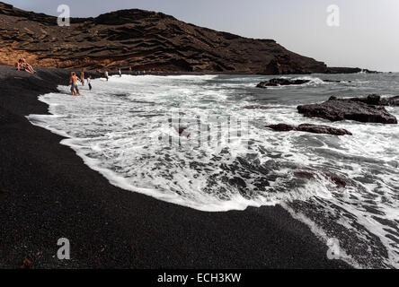 Plage de galets noirs près de El Golfo, les gens se baigner dans la mer, cratère volcanique, Lanzarote, îles Canaries, Espagne Banque D'Images