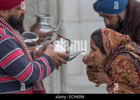 Les pèlerins de l'eau potable, saint Gurudwara Bangla Sahib, temple sikh, Delhi, Inde Banque D'Images