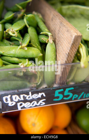 Les petits pois cultivés localement avec des fruits importés dans un supermarché biologique UK Banque D'Images