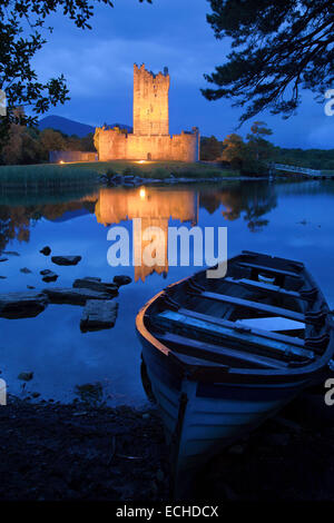 Bateau de pêche et le Château de Ross allumé au crépuscule, Lough Leane, le Parc National de Killarney, comté de Kerry, Irlande. Banque D'Images