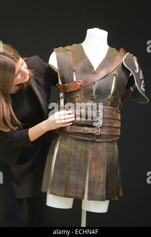 Londres, Royaume-Uni. 12 décembre 2014. Un employé de Christie's organise un roman cuir armure faite pour Russell Crowe comme Maximus dans le film Gladiator, 2000 Estimation  : 000 GBP. Christie's dévoile des souvenirs de Hollywood Icônes & Légendes de la musique Pop Culture 20/21 Vente d'avance sur une vue du public du 13 au 16 décembre 2014, avec la vente aux enchères qui aura lieu le 16 décembre. La vente célèbre certains des grands noms du 20ème siècle du cinéma et de la musique, avec des costumes et de scénarios de films, des instruments et des paroles de chansons. Banque D'Images