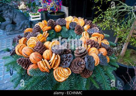 Une couronne de Noël avec ses décorations d'oranges, des tranches de pommes de pin d'orange à l'extérieur de l'entrée de Liberty's department store à Londres UK KATHY DEWITT Banque D'Images