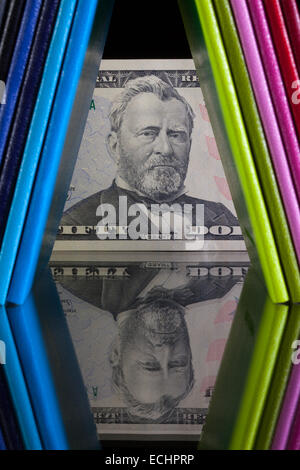 Douze couleurs différentes agendas et US dollar billet sur un bureau en verre Banque D'Images