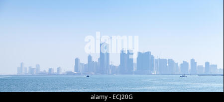 Des toits de la ville de Manama, Bahreïn. Les gratte-ciel modernes se tenir dans la brume à l'horizon Banque D'Images