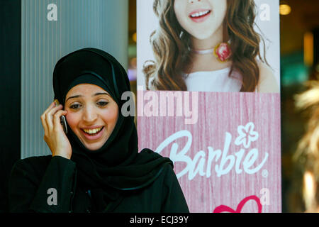 Jeune femme musulmane en foulard noir appelant téléphone mobile, hijab femme, fond dans la publicité sur la Barbie, Prague Tchèque République femme à la mode Banque D'Images