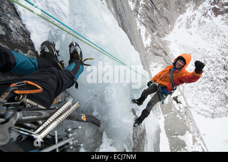 Un grimpeur rappels hors tension après une difficile première ascension d'une escalade de glace au début de l'automne. Banque D'Images