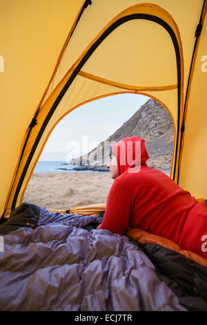 Backpacker femelle donne de tente de camping sauvage alors qu'à la plage Horseid, Moskenesøy, îles Lofoten, Norvège Banque D'Images