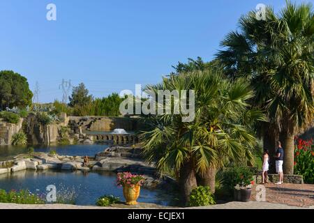 La France, l'Hérault, Béziers, Saint Adrien's garden, classé jardin remarquable (Jardin remarquable), jardin paysagé créé dans une carrière datant du Moyen-Âge, en couple sur un chemin qui envisage un plan d'au pied d'un palmier Banque D'Images