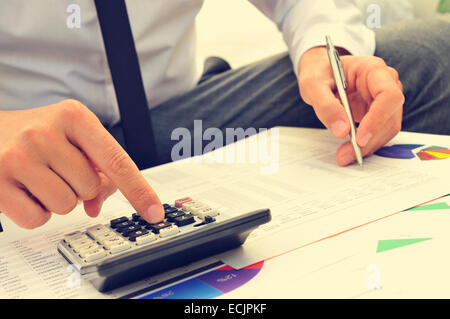 Libre d'un jeune homme avec vérification des comptes d'une calculatrice Banque D'Images