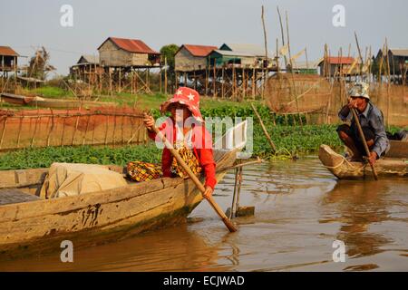 Le Cambodge, la province de Siem Reap, Kompong Kleang, maisons sur pilotis village le long du lac Tonle Sap, les gens se déplaçant le long de chaloupe Banque D'Images