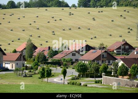France, Doubs, Haut Doubs, Le Barboux, lottissement en périphérie du village et bottes de foin dans les pâturages environnants Banque D'Images