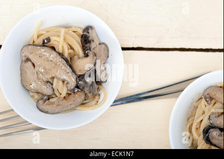 Les pâtes spaghetti italien et des champignons sauvages sur table en bois rustique Banque D'Images