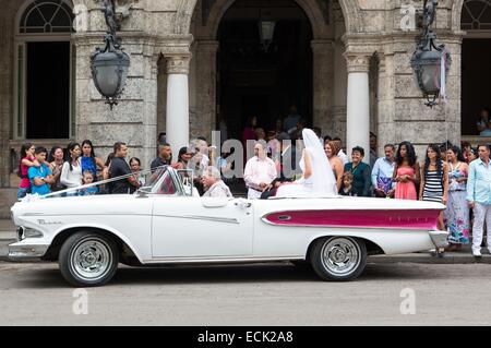 Cuba, La Havane, Centro Habana, jeunes mariés assis dans une voiture américaine en face de l'hôtel Palacio de Matrimonios sur le Paseo del Prado Banque D'Images