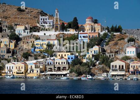 Grèce, Îles du Dodécanèse, l'île de Rhodes, Symi, frontons néoclassiques maisons sont mis en scène sur les collines surplombant la mer et le port Banque D'Images