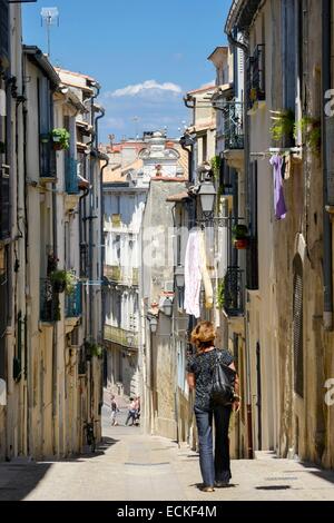 La France, Hérault, Montpellier, refuge street, femme de retour de marcher dans une zone piétonne ruelle bordée de maisons Banque D'Images