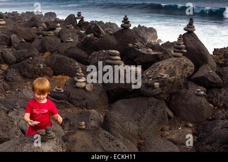 La France, l'île de la réunion, Etang Sale, Etang Sale les Bains, Le Gouffre, paysage marin, petite fille la construction d'un cairn au milieu des roches volcaniques Banque D'Images