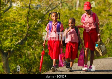 L'Ile Maurice, l'île Rodrigues, La Ferme, groupe de jeunes filles en uniforme est venu créole à la maison de l'école sur une route Banque D'Images