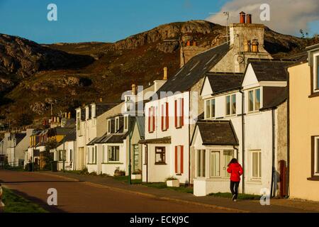 Royaume-uni, Ecosse, Wester Ross, Shieldaig, vue horizontale de la rue principale d'un village de pêcheurs à pied qu'une femme en rouge en automne Banque D'Images