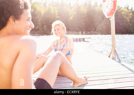 Happy couple relaxing on pier au lac aux beaux jours Banque D'Images