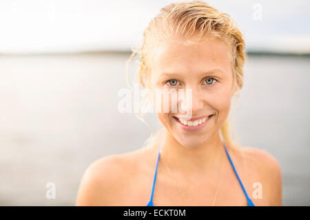 Portrait of smiling young woman against lake Banque D'Images